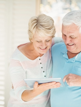 technology, age and people concept - happy senior woman with laptop computer at home